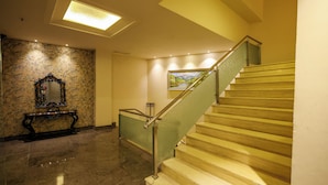 A staircase with a wooden finish and metal handrail, leading to an upper floor. - Godwin Meerut (Meerut)