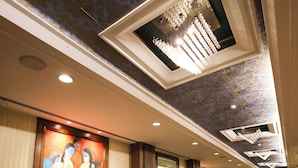 A spacious lobby with a marble floor, a large abstract painting on the wall, and a modern chandelier. - Godwin Meerut (Meerut)