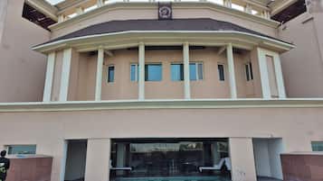 A large building with a pool, multiple windows, and a balcony.