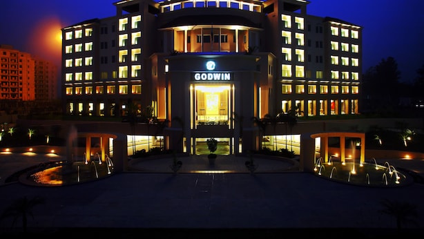 A multi-story hotel with a prominent entrance and a well-lit facade. - Godwin Meerut (Meerut)