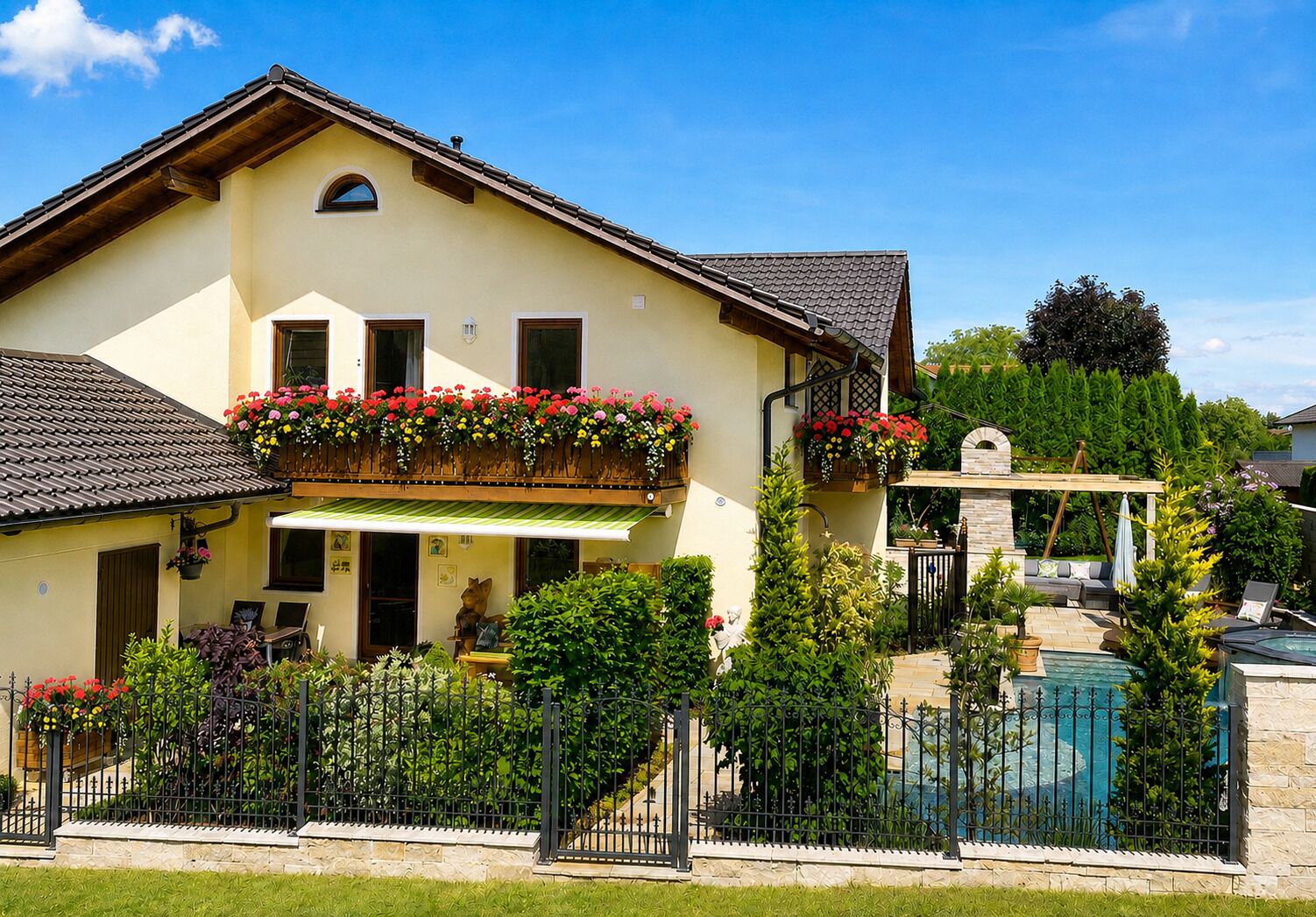 Ein zweigeschossiges Haus mit Balkon, Pool und Garten.