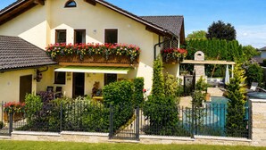 Ein zweigeschossiges Haus mit Balkon, Pool und Garten.