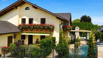 Ein zweigeschossiges Haus mit Balkon, Pool und Garten.