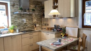 Eine moderne Küche mit Granit-Arbeitsplatten, Holzschränken und einer zentralen Kochinsel.