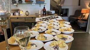 Una zona de bar con una mesa larga que muestra platos de aperitivos y una copa de champán.
