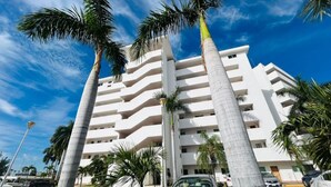 A multi-story hotel with a modern architectural design, featuring balconies and a parking area with cars. - Beautiful in marina, amazing views by Gpsrentas (Mazatlán)