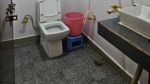 A small bathroom with a toilet, a sink, and a shower. - Vrindavan Resort (Mathura)