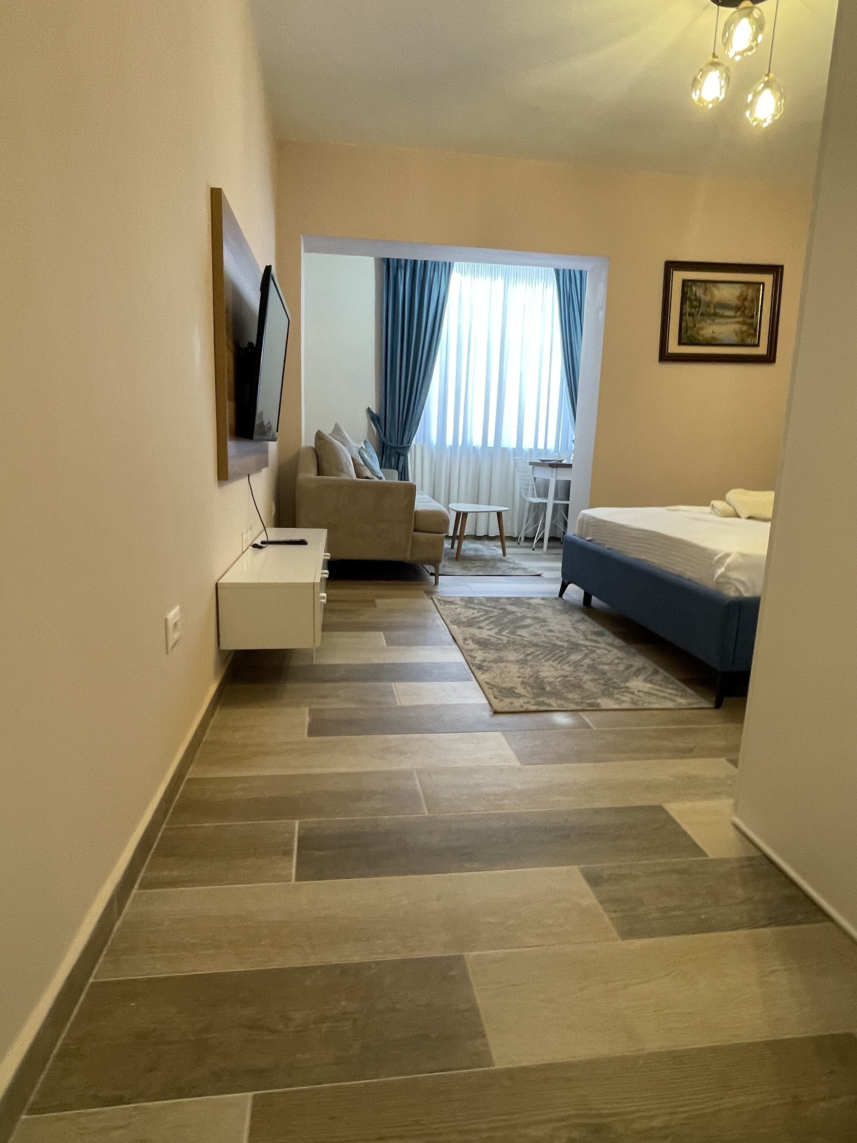 Ein modernes Hotelzimmer mit einer Couch, einem Bett, einem kleinen Tisch und einem Sessel.