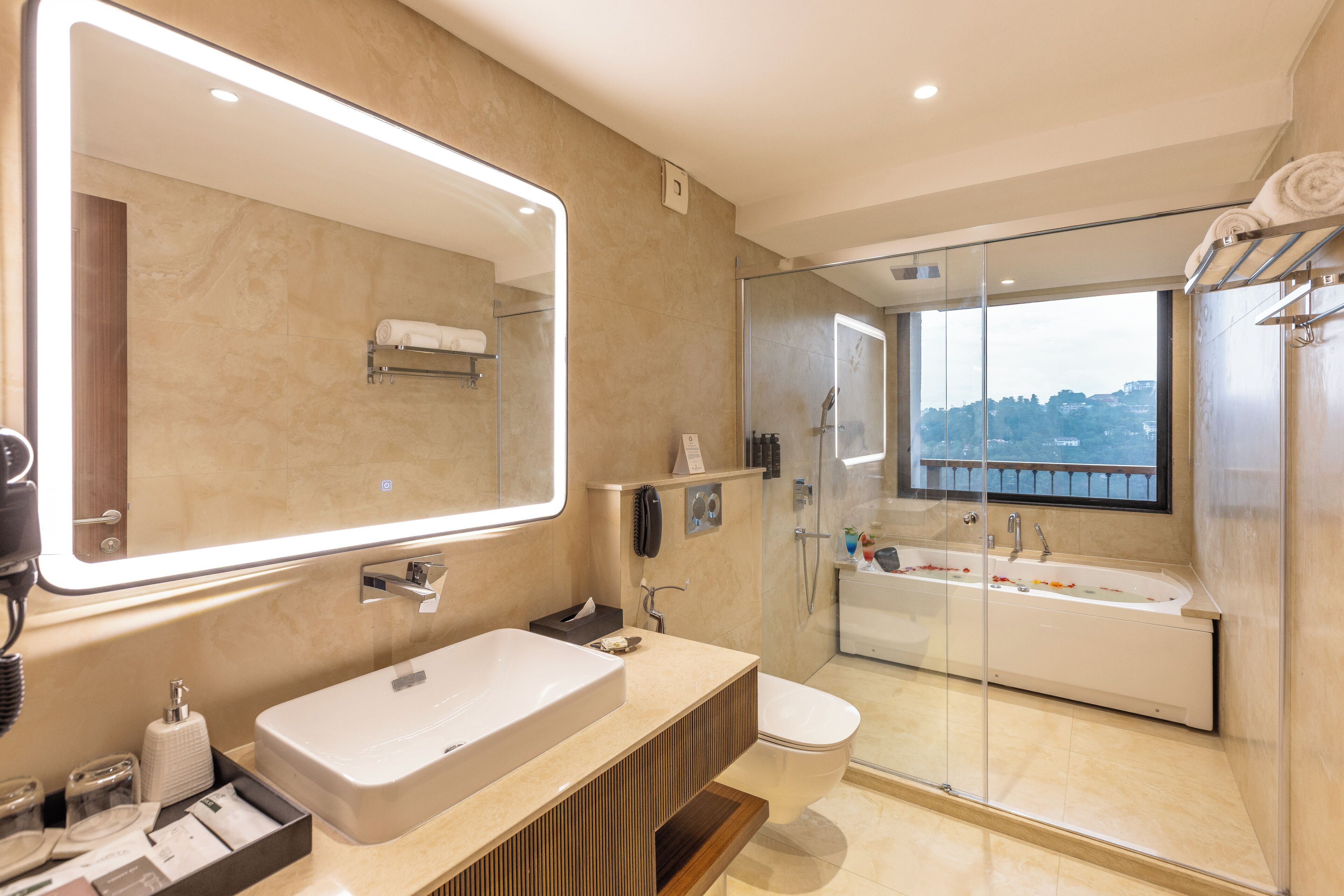 A modern bathroom with a large mirror, a bathtub, and a glass-enclosed shower.