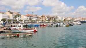 A marina with boats docked, a clear sky, and buildings in the background. - Villa Francisca Cambrils (Cambrils)