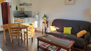 Ein Wohnzimmer mit Sofa, Couchtisch und Essbereich.