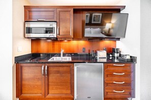 Uma cozinha compacta com micro-ondas, torradeira e cafeteira.