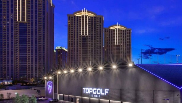A modern building with a sign reading 'TOPGOLF LAS VEGAS' and a parking lot in front. - MGM Signature | No Resort Fees, Jacuzzi & Pools (Las Vegas)