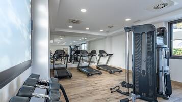 A modern gym with treadmills, dumbbells, and weight machines.