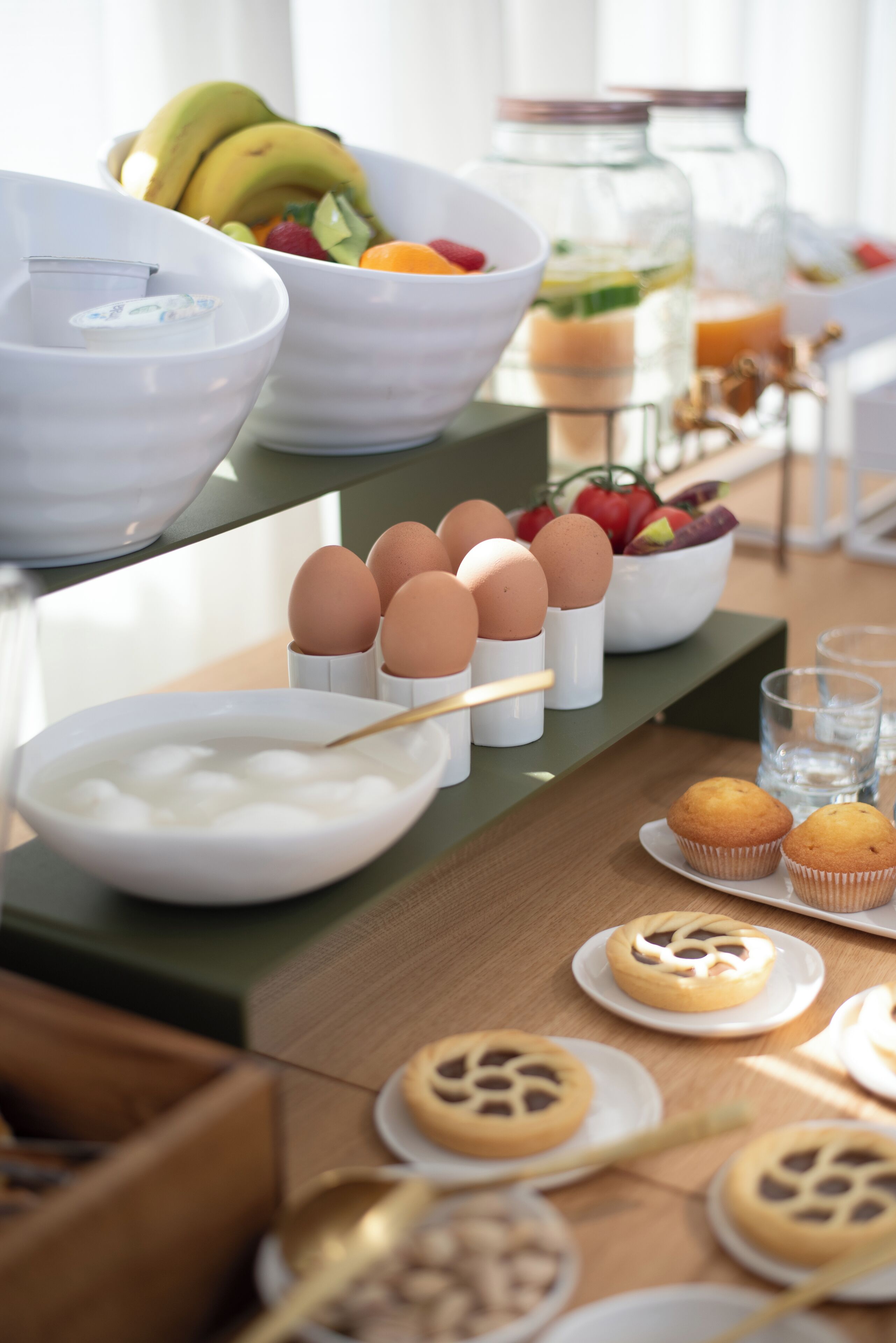 Un buffet de petit-déjeuner proposant une variété d’aliments, notamment des œufs, des muffins et des fruits.