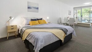 A modern bedroom with a bed, bedside tables, a desk, and a chair. - A Modern & Comfy Studio Next to Darling Harbour (Sydney)
