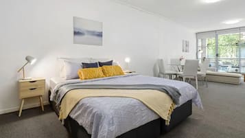 Tabla de planchar con plancha y ropa de cama