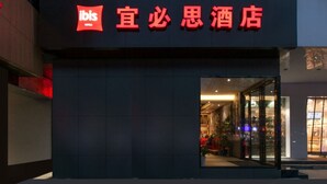 L’extérieur de l’hôtel Ibis, avec son grand panneau rouge bien visible et son entrée en verre.