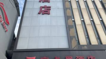 Placa de hotel com o nome 'ibis' e caracteres chineses.