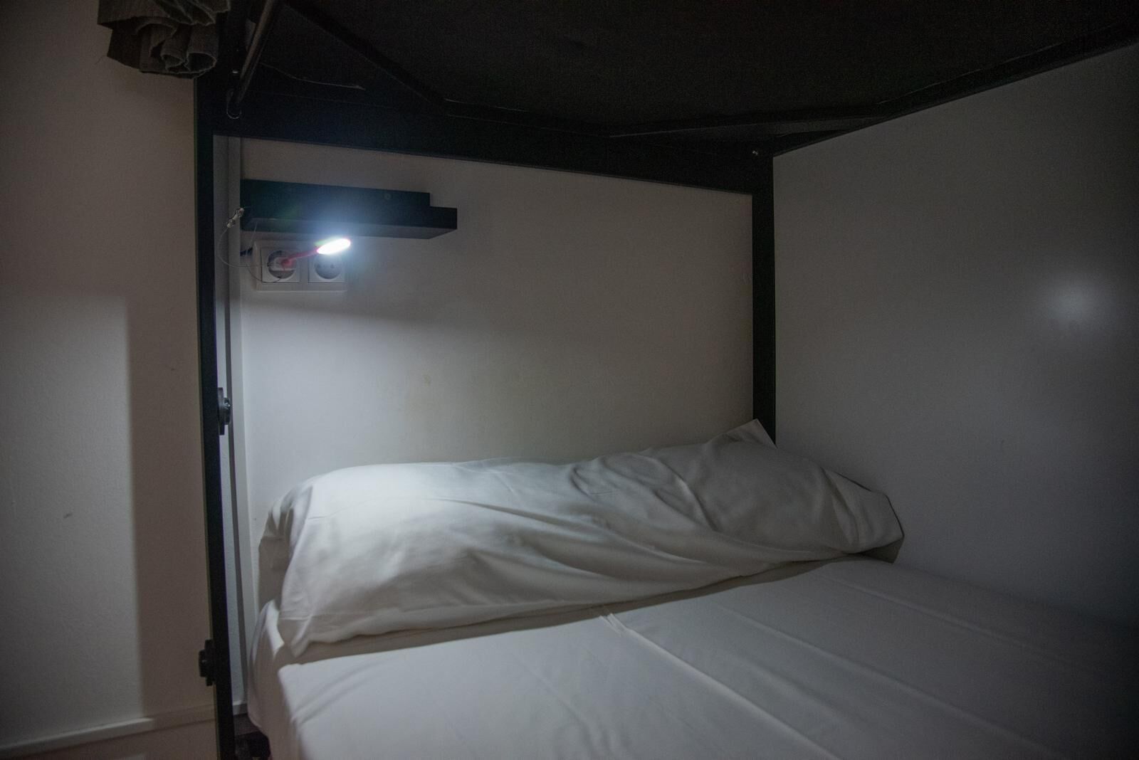 A bunk bed with a single bed on top and a headboard.