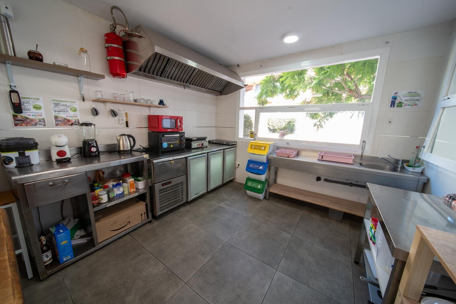 A kitchen with stainless steel appliances, a window with a view, and storage cabinets.