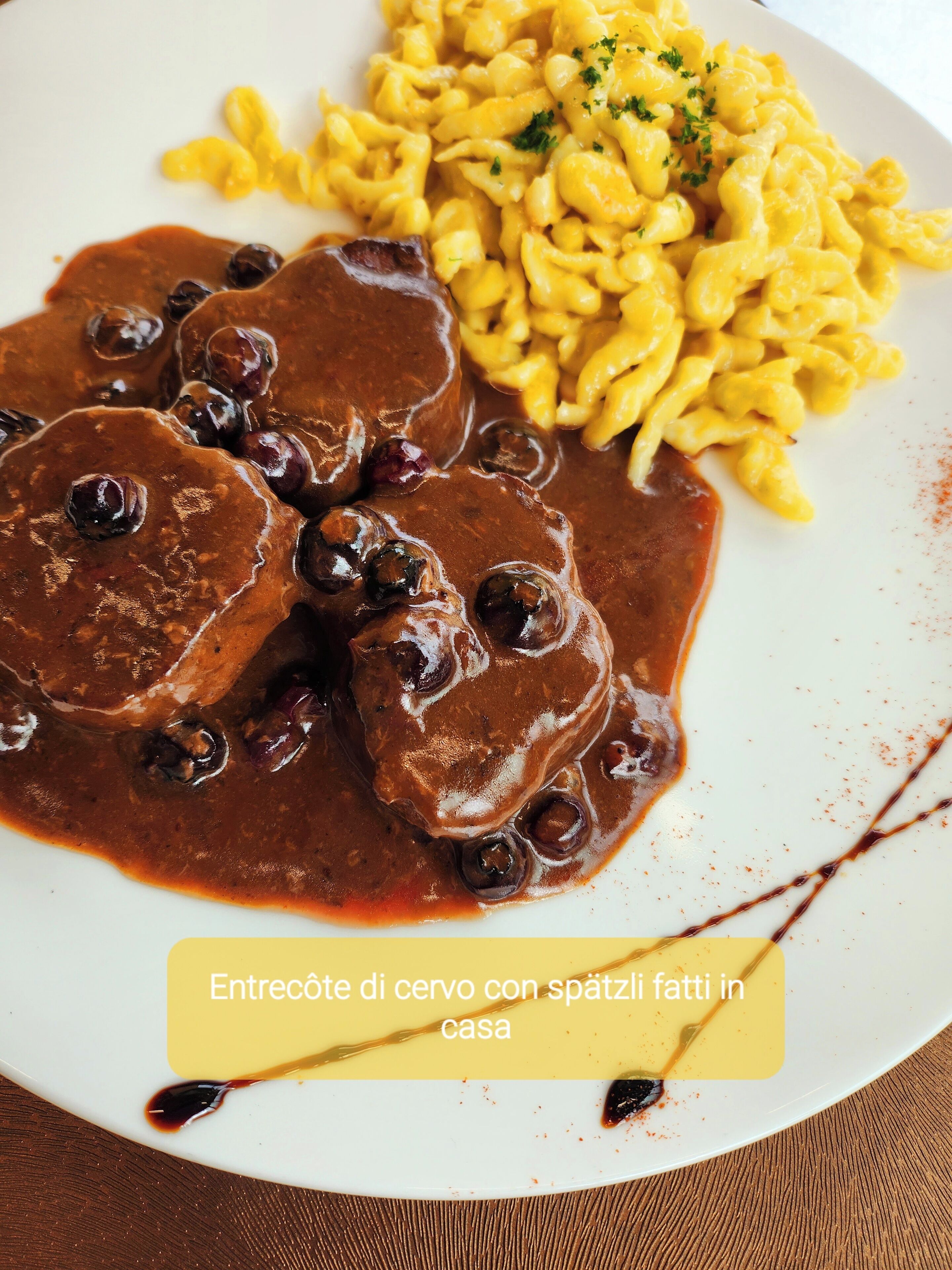 A plate of meat with gravy and macaroni.