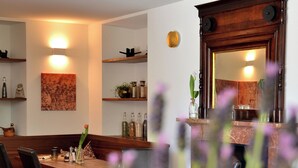 A dining area with wooden furniture, a table set with plates and glasses, and shelves with decorative items. - Boutique Hotel Fusio (Lavizzara)