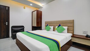 A hotel room with a bed, a desk, a chair, and a wardrobe. - Itsy Hotels Usha Utsav (Faizabad)