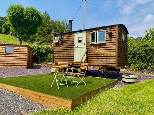 A wooden cabin with a small deck and a window. - A quiet and cosy Shepherds Hut, with wood burning fire with scenic views (Conwy)