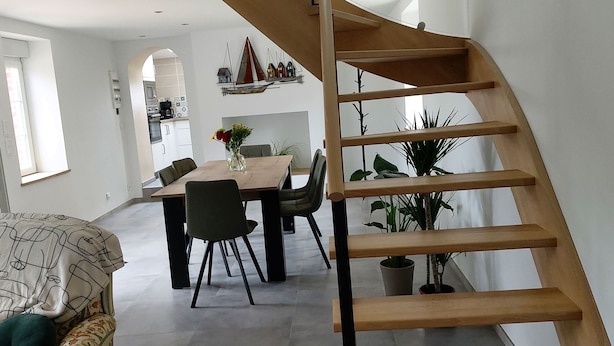 Un interior moderno con comedor, escalera y sala de estar.