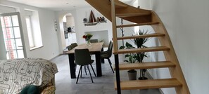 Un interior moderno con comedor, escalera y sala de estar.