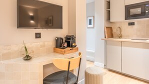A modern kitchen with a flat-screen TV, a coffee machine, and a microwave. - Maison Letellier - Studio just near Eiffel Tower (Paris)