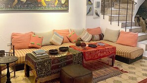 A living room with a sofa, a coffee table, a patterned rug, and a painting on the wall. - Bab El Fen  (Tangier)