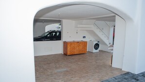 Ein geräumiges Zimmer mit einem Holzschrank, einer Waschmaschine und einem draußen stehenden Auto.