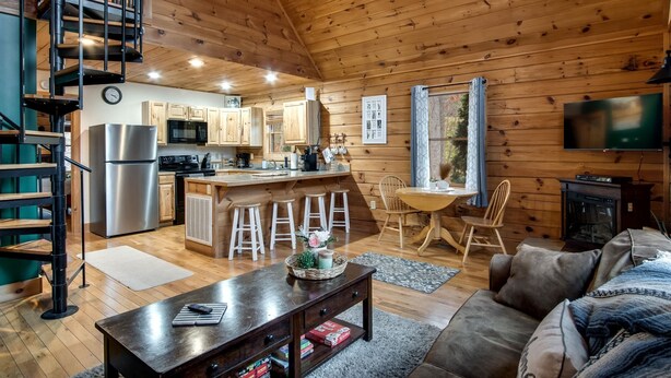 Ein Holzhäuschen-Interieur mit Küche, Essbereich und Wohnzimmer.