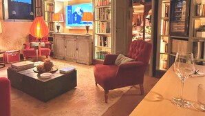 A cozy living room with a fireplace, a television, and a bookshelf. - 18th century residence with garden and sauna, close to the Navigli District (Milano)