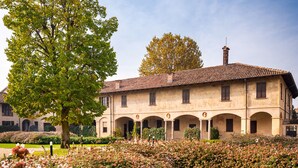 A building with a courtyard surrounded by flowers. - 18th century residence with garden and sauna, close to the Navigli District (Milano)