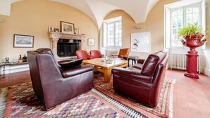 A living room with a fireplace, leather sofas, a coffee table, and a patterned rug.