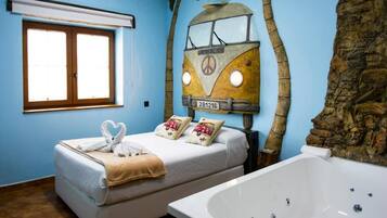 Una stanza con un letto, una grande vasca da bagno e un murale raffigurante un furgone.