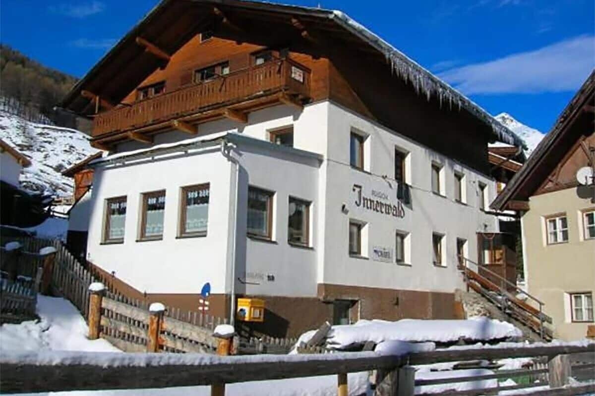 A white building with a wooden balcony and a sign that reads "Innermald."