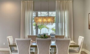 Un espace repas comprenant une table, des chaises et un luminaire suspendu.
