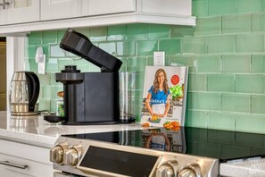 Une cuisine équipée d’une machine à café, d’un livre de recettes et d’une cuisinière.