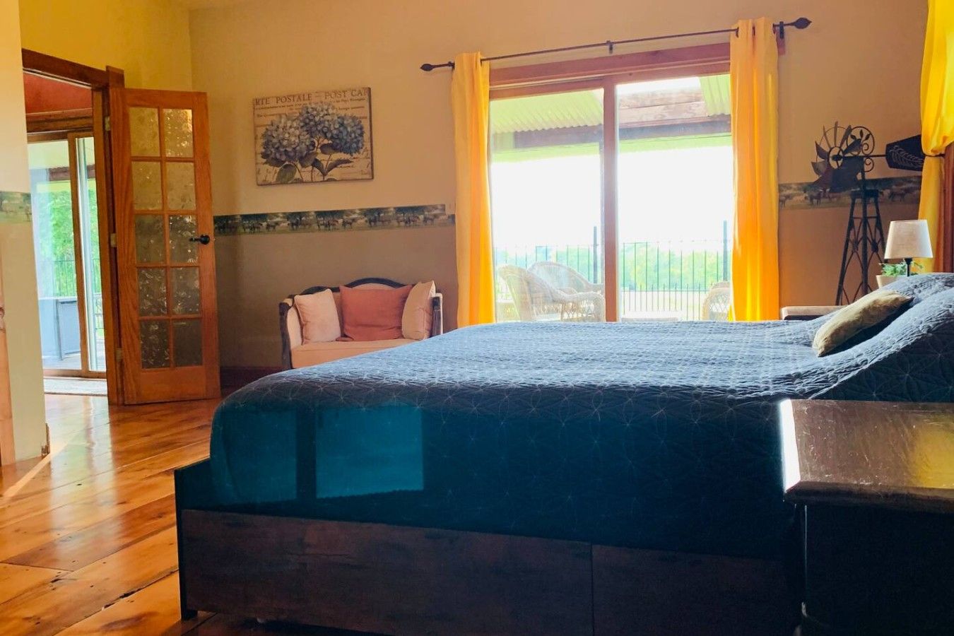 Une chambre à coucher avec un lit, une chaise, une fenêtre avec des rideaux et une porte.