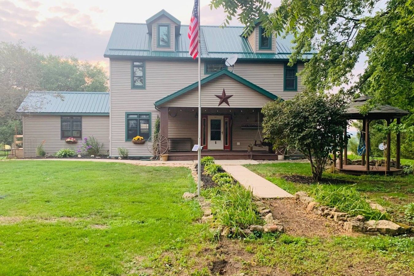 Ein zweistöckiges Haus mit Veranda, einer Sternenverzierung und einer amerikanischen Flagge.