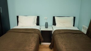 A twin room with two beds, a small bedside table with a vase, and a power outlet on the wall. - Restland Dilijan Family Hotel  (Dilijan)