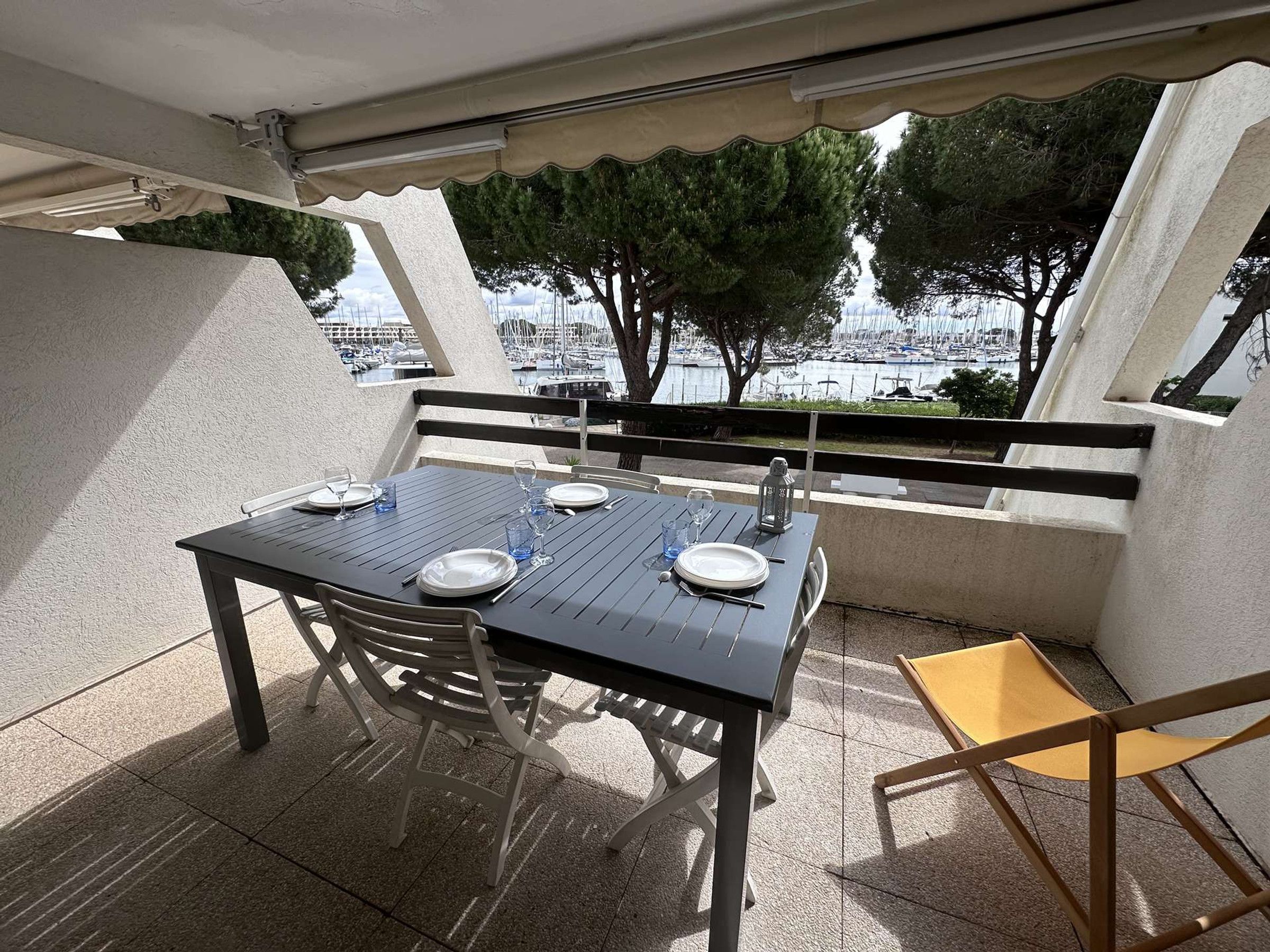A table set for two with a view of a marina.