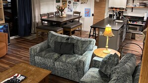 Ein geräumiges Wohnzimmer mit einer großen Eckcouch, einem Holztisch und einem Essbereich mit dunklem Holztisch und Stühlen.