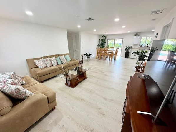 A spacious living room with a sofa, coffee table, and TV stand.