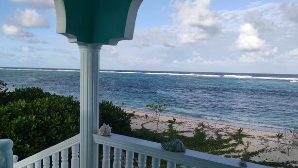 En balkon med udsigt over havet og stranden.