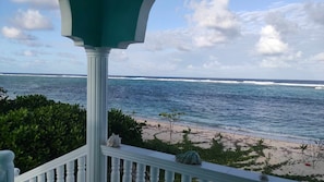 A balcony with a view of the ocean and beach. - Whitesands Beach Resort (San Isidro)
